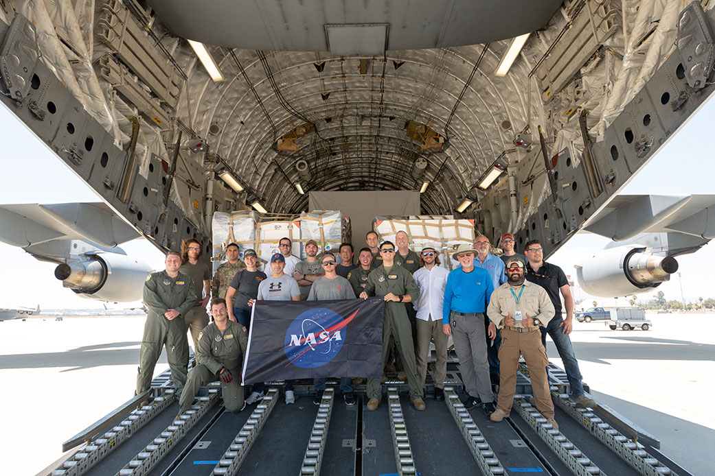 Some of the people who helped to load the hardware for the Surface Water and Ocean Topography (SWOT) satellite's research instruments onto a C-17 airplane pose for a picture.